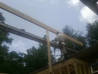Carpenter setting a ridge beam over a new addition frame — Ice Dam Removal by Roofing Brothers in Long Grove