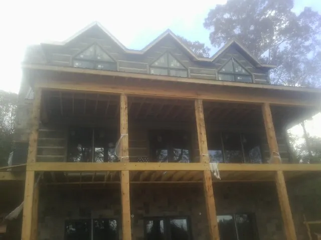 Dormers and porch framing on a large log home under construction — Roof Coating work by our crew in Long Grove