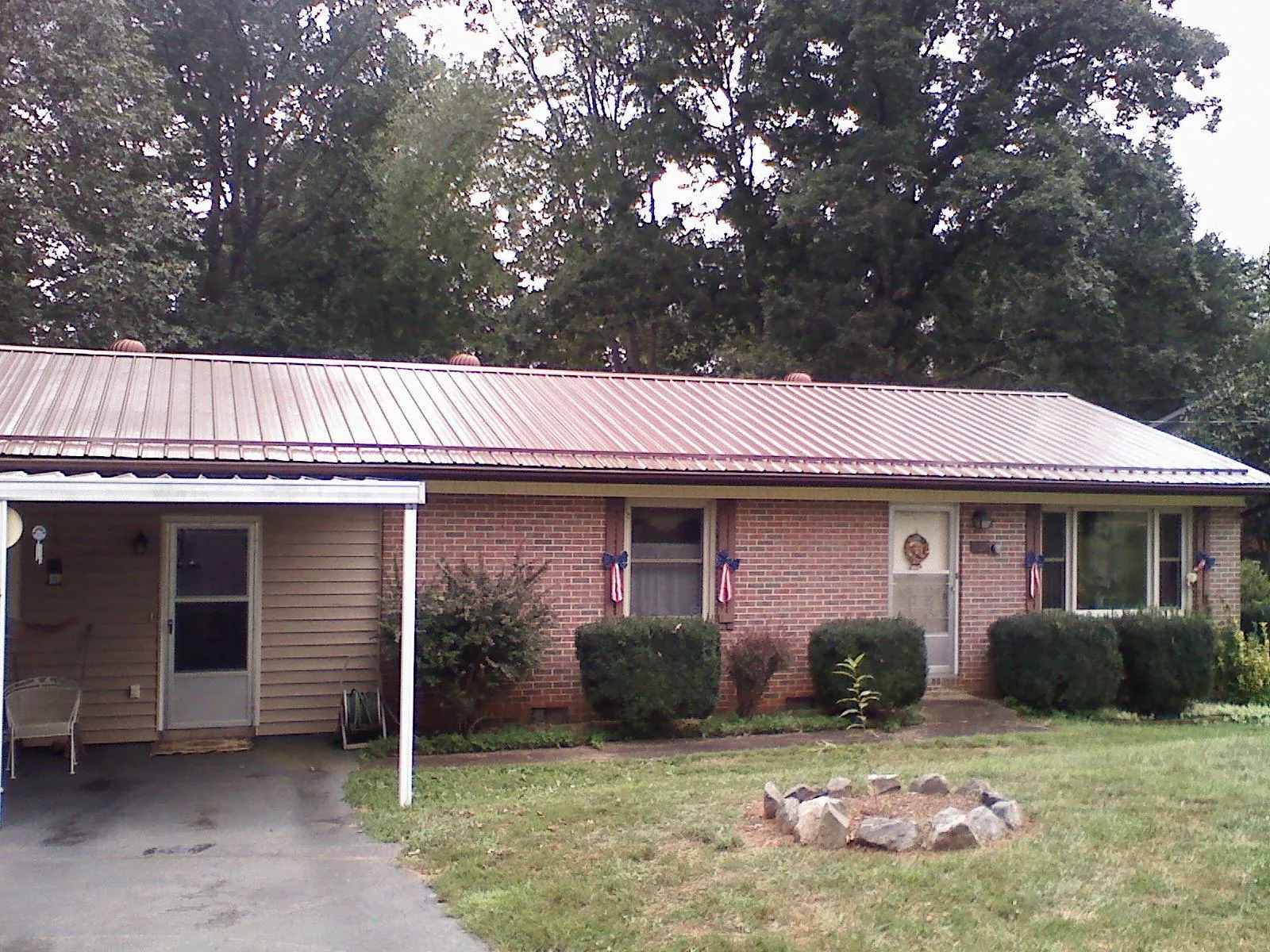 Bronze metal roof and carport on a brick ranch home — Roof Repair work by our crew in Long Grove